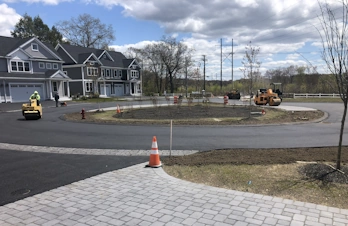 Asphalt rollers compacting a newly paved residential cul-de-sac with paver aprons in Lexington, MA
