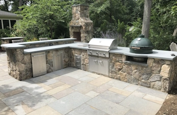 Outdoor kitchen with brick chimney, bar, and smoker in Concord, Massachusetts