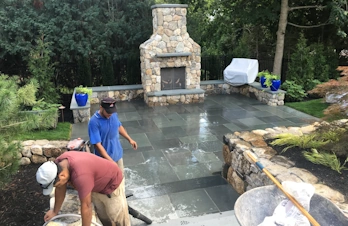 Custom designed front steps with bluestone treads, bluestone tiles and New England fieldstone retaining wall.