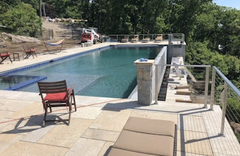 Infinity pool with waterfall edge and natural stone coping in Gloucester, Massachusetts