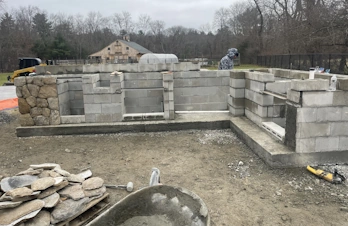 Outdoor kitchen under construction with masonry block foundation in Holliston, Massachusetts