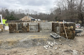 Outdoor kitchen with stone veneer and large paver patio in Holliston, Massachusetts