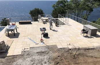Expansive natural stone pool deck overlooking the ocean in Gloucester, Massachusetts