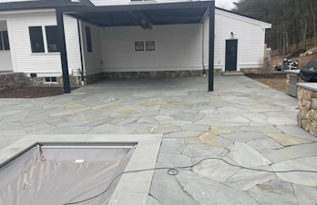 Custom backyard plunge pool and natural stone coping installed by S. Phaneuf & Associates in Concord, Massachusetts.