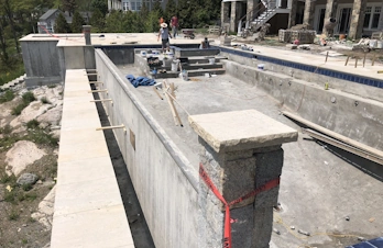 Infinity pool edge with custom natural stone masonry in Gloucester, Massachusetts