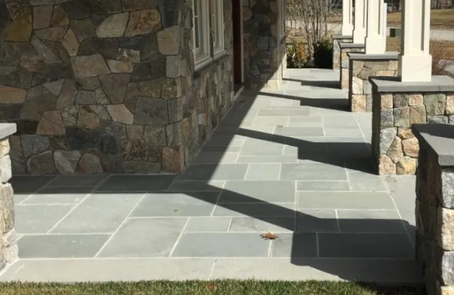 Natural stone front porch with masonry columns and steps in Groton, Massachusetts