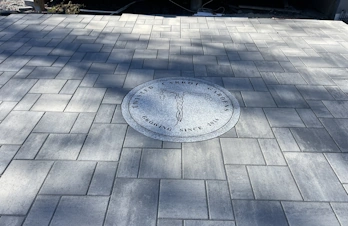 Decorative paver patio with custom stone inlay at Twisted Carrot Farm in Holliston, Massachusetts